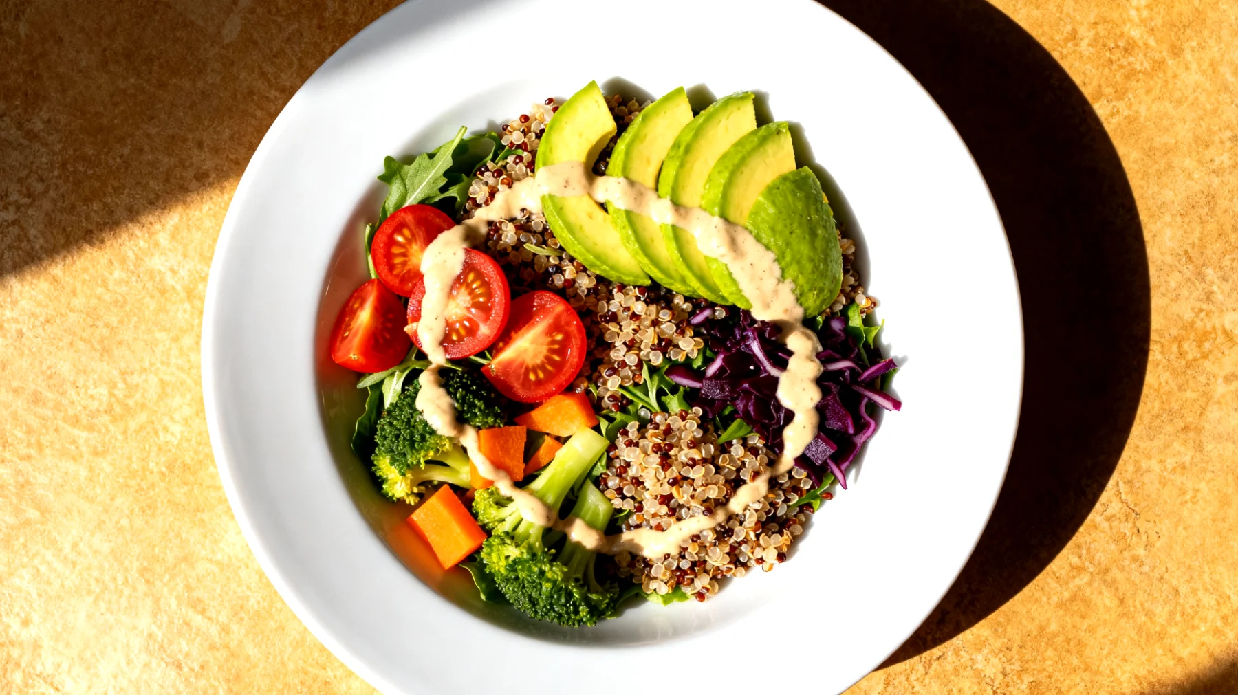 Kinoa salatası mevsim sebzeleri, avokado ve tahini sosuyla"
